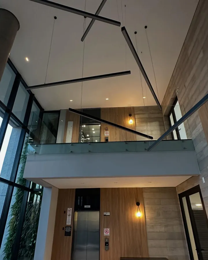 Hall de pé-direito duplo — forro e mezanino com iluminação suspensa